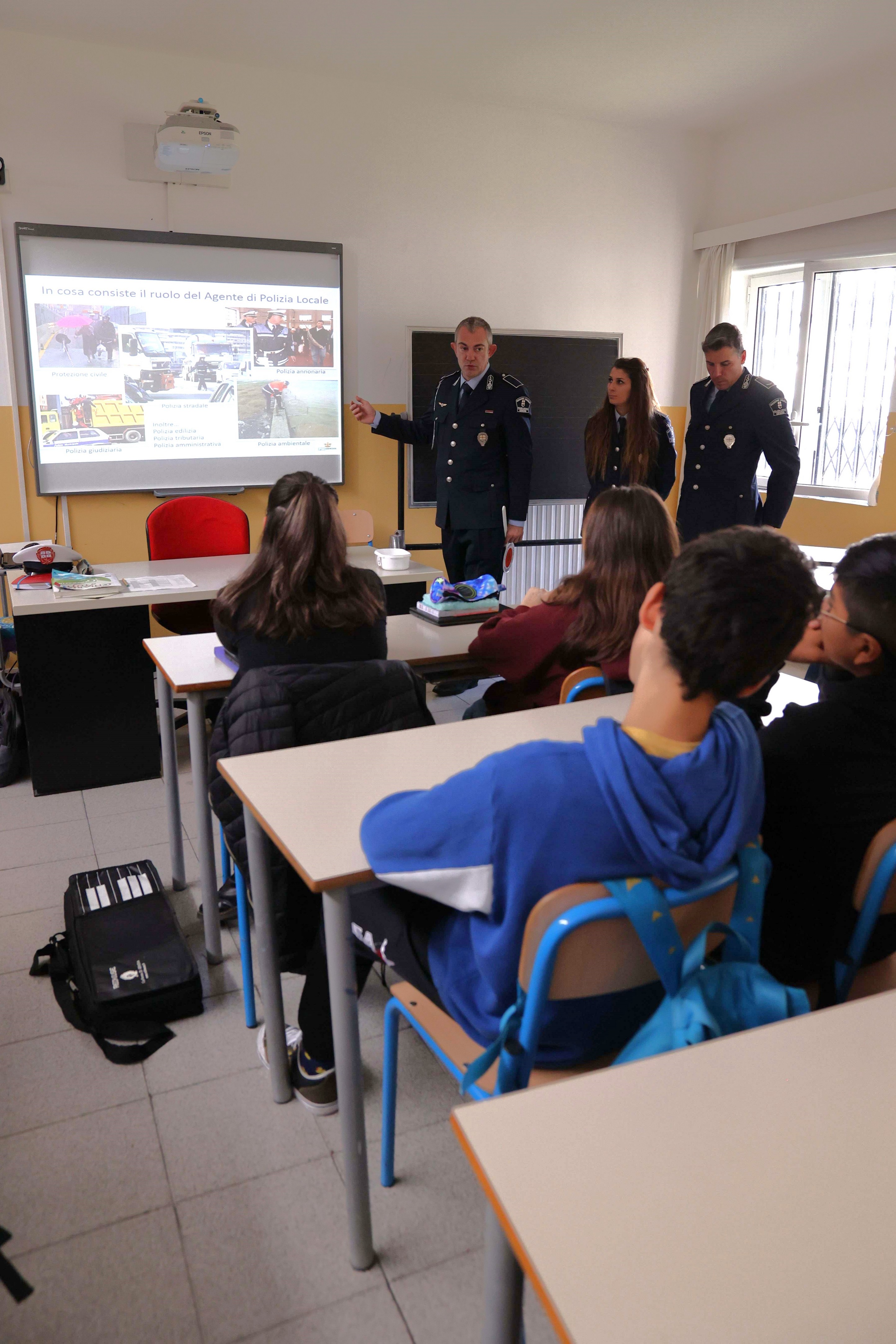 Agenti della Polizai Locale che fanno una lezione di educazione stradale in una classe di bambini