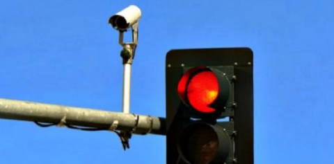 foto di un semaforo con luce rossa e della telecamera per la registrazione delle infrazioni